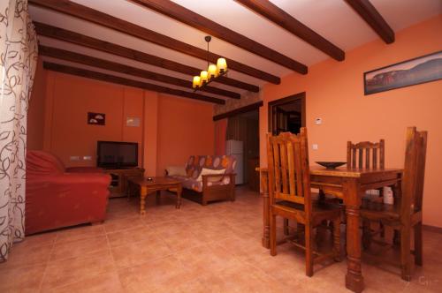 a living room with a red couch and a table at Alojamientos Rurales la Fuente in Villalba de la Sierra