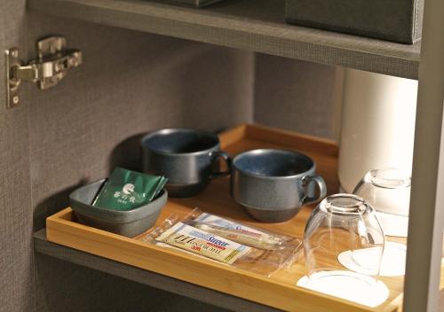 three pots and pans on a shelf in a kitchen at ORIENTAL HOTEL KYOTO ROKUJO in Kyoto