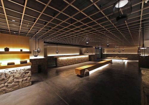 a lobby with a bench and a stone wall at ORIENTAL HOTEL KYOTO ROKUJO in Kyoto