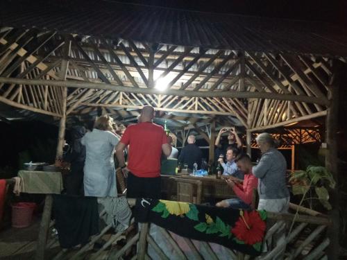 a group of people standing around a bar in a tent at De Salak Homestay in Bogor