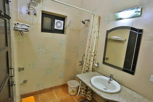 a bathroom with a sink and a mirror at Kasang Regency Hill Resort in Lansdowne