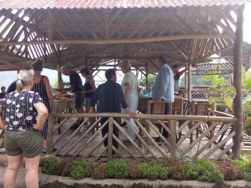 a group of people standing under a wooden structure at De Salak Homestay in Bogor