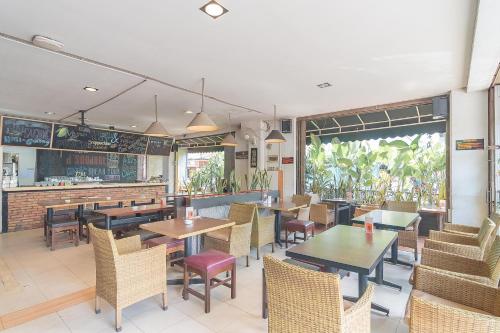 a restaurant with tables and chairs and a bar at RedDoorz at H Agus Salim Street Pontianak in Pontianak