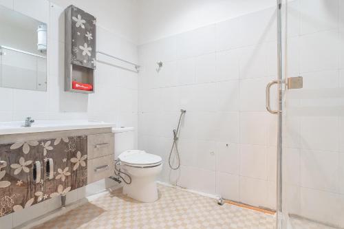 a bathroom with a toilet and a sink and a shower at RedDoorz at H Agus Salim Street Pontianak in Pontianak