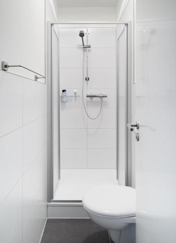 a bathroom with a glass shower with a toilet at Pension Wagener in Wachtendonk