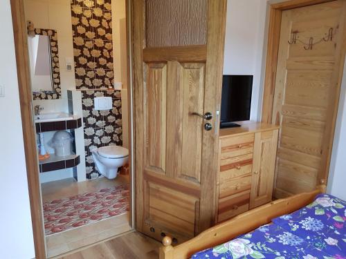 ミコワイキにあるEko Zagroda Bocianie Gniazdoのバスルーム(トイレ付)、木製のドアが備わります。