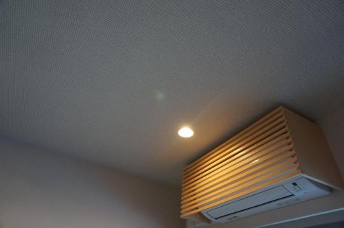 a room with a ceiling with a light and a microwave at Hotel Imari Aioibashi Bettei in Imari