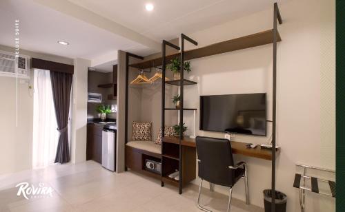 a living room with a desk and a television in a room at Rovira Suites in Dumaguete