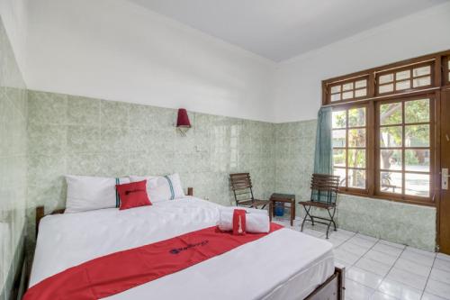 a bedroom with two beds with red pillows at RedDoorz @ Sagan Jogja 2 in Yogyakarta