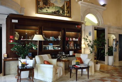 a living room with two white chairs and tables at Ruzzini Palace Hotel in Venice