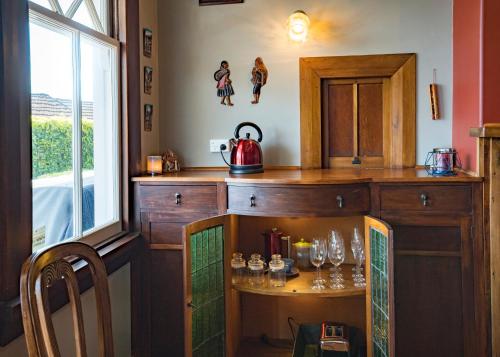 a kitchen with a table with glasses on it at Delightful on Devonport in Tauranga