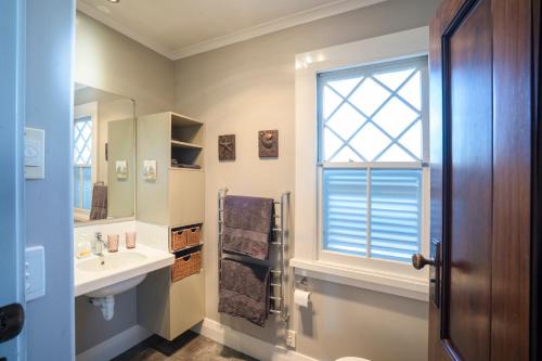 a bathroom with a sink and a window at Delightful on Devonport in Tauranga