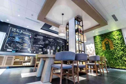a restaurant with a bar with blue stools at Campanile Shanghai Huaihai in Shanghai