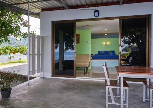 a house with a dining table and a view of the ocean at Elephant Bay Resort in Ko Chang