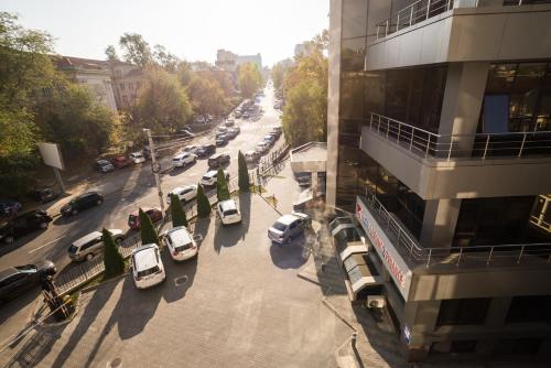 a city street filled with parked cars next to a building at The Central Collection Apartments in Chişinău