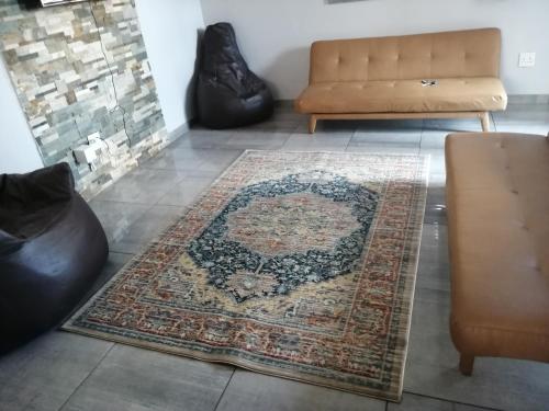 a living room with a rug and a couch at Sunflower Guesthouse in Vanderbijlpark