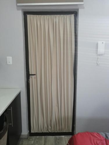 a door with a curtain in a room at Sunflower Guesthouse in Vanderbijlpark