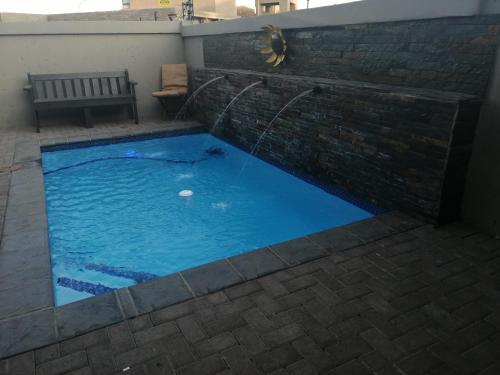 a swimming pool with a water fountain at Sunflower Guesthouse in Vanderbijlpark