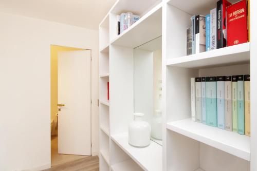 um quarto com prateleiras brancas com livros em Crispi Luxury Apartments - My Extra Home em Roma