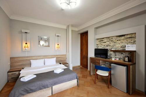 1 dormitorio con 1 cama y escritorio con ordenador en Hotel Livin en Tiflis