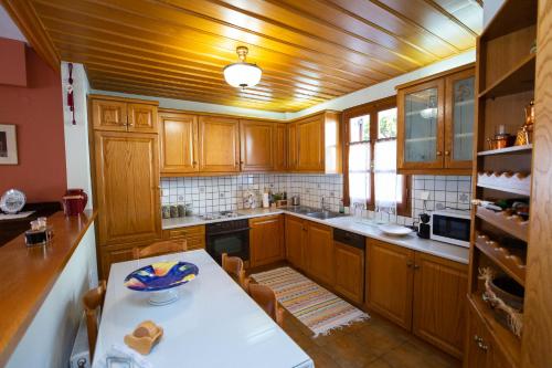 a kitchen with wooden cabinets and a white table at Zoes Garden Delphi in Delfoi