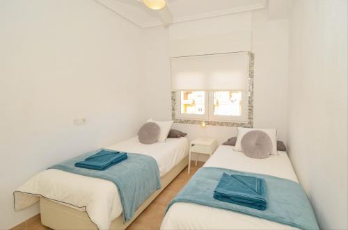 sypialnia z dwoma łóżkami i lustrem w obiekcie Punta Prima Pleasure with private parking in a gated community close to the beach w mieście Torrevieja