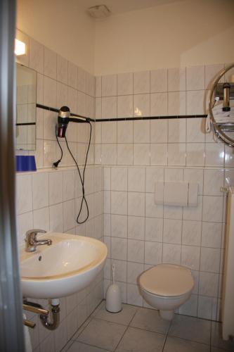 a bathroom with a sink and a toilet at Hotel und Restaurant Knesebecker Hof in Knesebeck