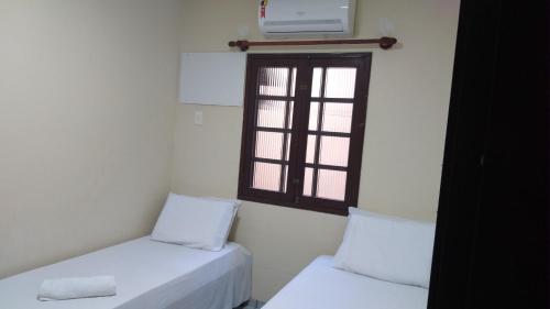 a room with two beds and a window at Praia Apart Hotel in Natal