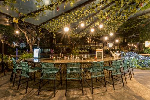 a large bar with green chairs and lights at Holiday Inn Cikarang Jababeka by IHG in Cikarang