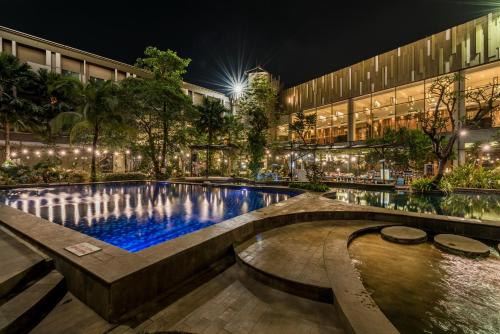 a building with a swimming pool at night at Holiday Inn Cikarang Jababeka by IHG in Cikarang