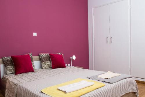 
a bedroom with a bed and a dresser at Voula's Luxury Colored Apartment in Athens

