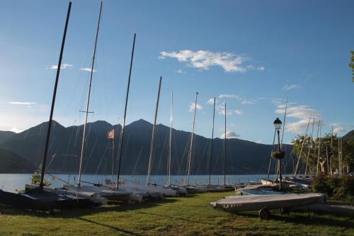 a group of sailboats parked on the grass near the water at Albergo Paradiso in Maccagno con Pino e Veddasca
