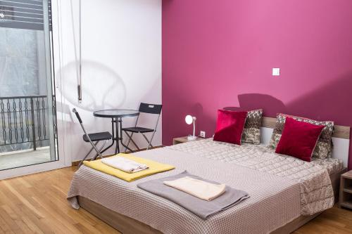 
a bedroom with a bed and a dresser at Voula's Luxury Colored Apartment in Athens
