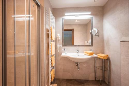 a bathroom with a sink and a shower at Hotel Garni Erler in Mayrhofen