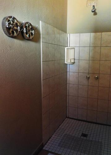 a shower stall in a bathroom with a tile floor at Vastrap Guest Farm in Grünau