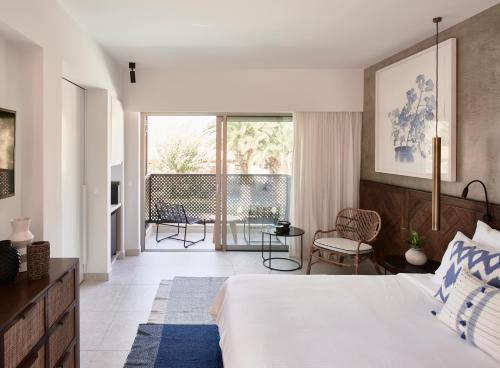 a bedroom with a bed and a balcony at Phāea Cretan Malia, a Member of Design Hotels in Malia