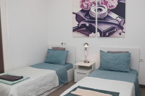 sypialnia z 2 łóżkami z niebieską i białą pościelą w obiekcie Dimitras Apartment w Atenach