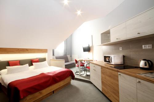 a hotel room with a bed and a kitchen at Hotel Strážnice in Strážnice