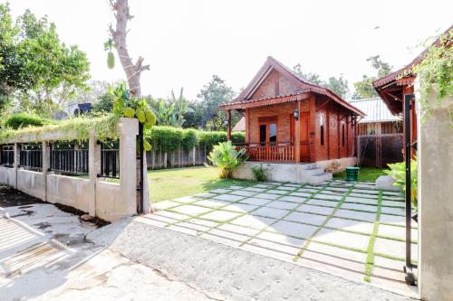 a house with a fence and a yard at Omah Teras Bata Guesthouse in Yogyakarta
