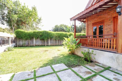 a house with a porch and a yard at Omah Teras Bata Guesthouse in Yogyakarta