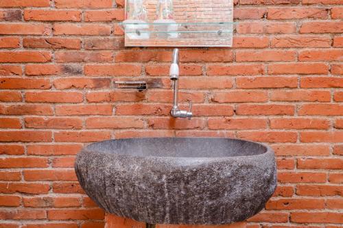 a stone sink attached to a brick wall at Omah Teras Bata Guesthouse in Yogyakarta