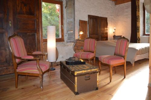 Un dormitorio con una cama y dos sillas y un baúl. en LA FREIRESSA, en Saint-Jean-des-Ollières