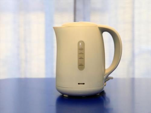 a white electric kettle sitting on a table at COTO Tokyo Shibuya 2 in Tokyo