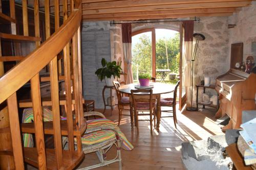 une salle à manger avec une table et un escalier en bois dans l'établissement LA FREIRESSA, à Saint-Jean-des-Ollières