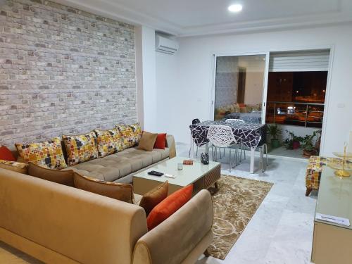 a living room with couches and a brick wall at Appartement S+1 Jardin De Carthage in Tunis