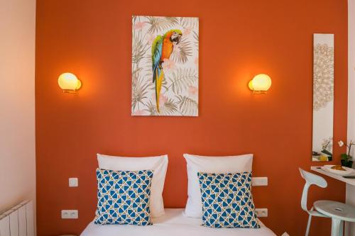 une chambre avec des murs orange et un lit avec deux oreillers dans l'établissement WS Haut-Marais - Carreau du Temple, à Paris