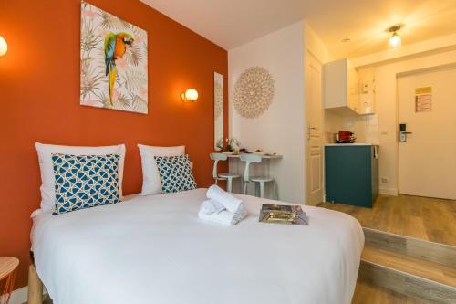 une chambre avec un grand lit blanc avec des murs orange dans l'établissement WS Haut-Marais - Carreau du Temple, à Paris