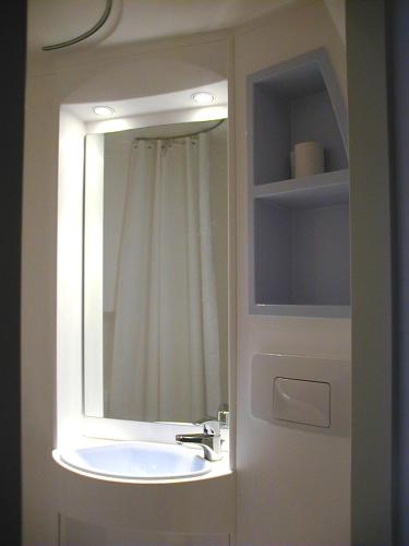 une salle de bain avec un lavabo et un miroir dans l'établissement Le Chalet du Ticou, à Bolquère-Pyrénées 2000