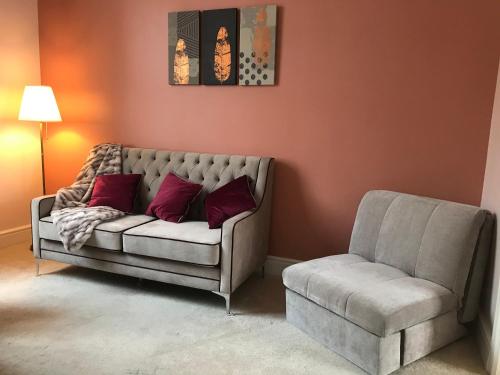 a living room with a couch and a chair at Velvet Nest 5 min walk from train station in Leamington Spa
