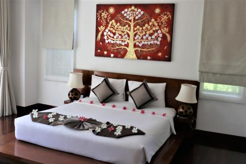 a bedroom with a large white bed with decorations on it at Laguna Villas Boutique Hotel in Ko Yao Noi